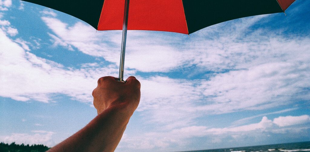 Umbrella in hand on a beach http://barnimages.com/