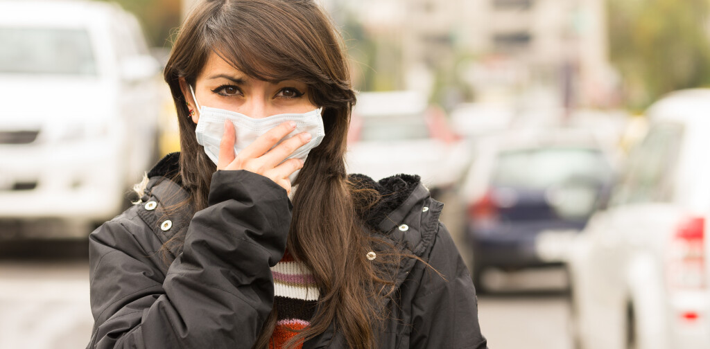portrait of young girl walking wearing a mask in the city street concept of pollution