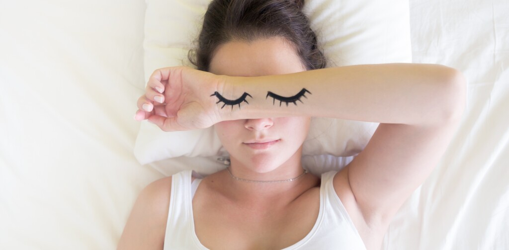 Painted sleeping eyes and Attractive brunette young woman in the white bed at morning time