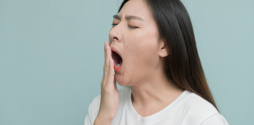asian young Women yawn on light blue background.