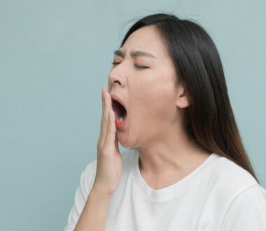 asian young Women yawn on light blue background.