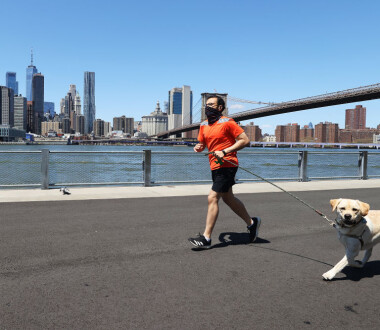 BROOKLYN, NEW YORK  - APRIL 28:  A Man runs with his dog while wearing a mask amidst the coronavirus pandemic at Brooklyn Bridge Park on April 28, 2020 in the Brooklyn Borough of New York City.  The World Health Organization declared coronavirus (COVID-19) a global pandemic on March 11th.  (Photo by Al Bello/Getty Images)