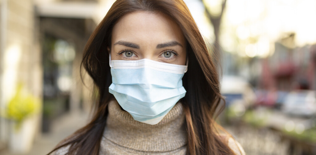 Portrait of an attractive young woman wearing a face mask to protect herself and others from airborne viruses while being outdoors in the city