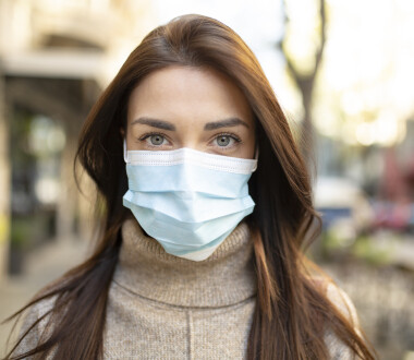 Portrait of an attractive young woman wearing a face mask to protect herself and others from airborne viruses while being outdoors in the city