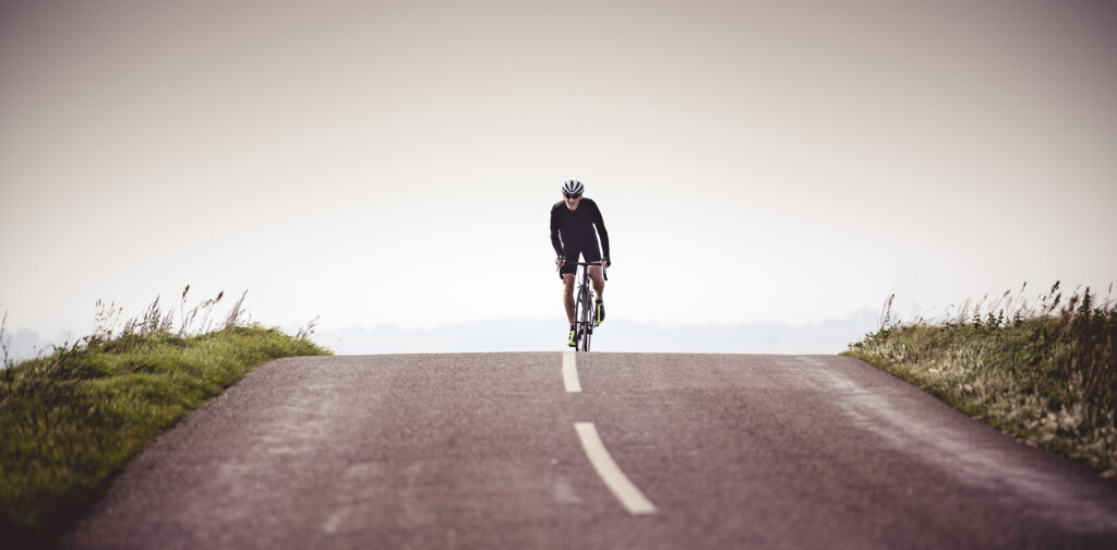 Portrait of a fit 50 year old male cyclist out of a training ride. Photographed in a modern contemporary style, colour, horizontal with some copy space. Photographed on the island of Møn in Denmark.